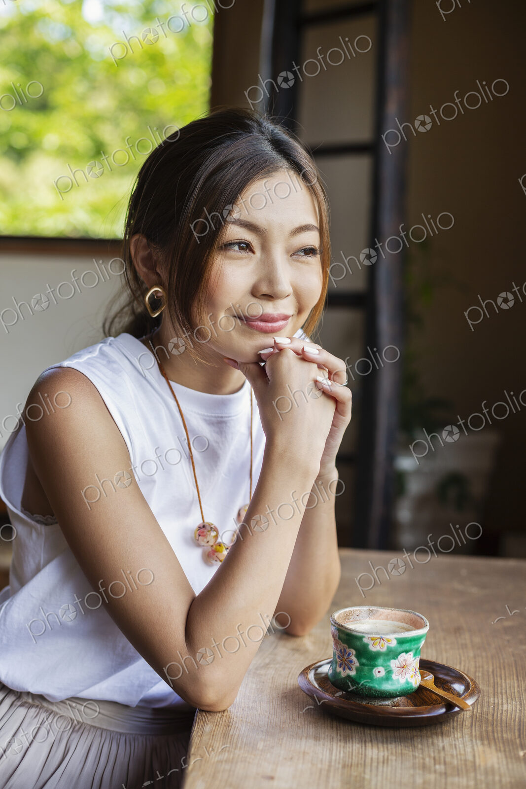 Smiling Japanese woman sitting at table in Japanese restaurant.