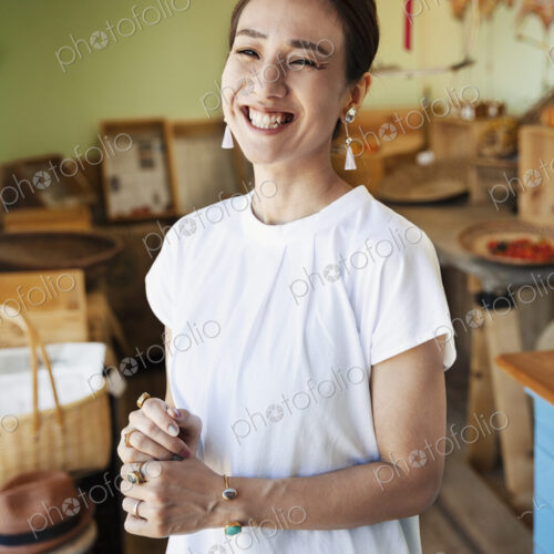Smiling Japanese woman standing in a farm shop, looking at camera. Smiling Japanese woman standing in a farm shop, looking at camera.