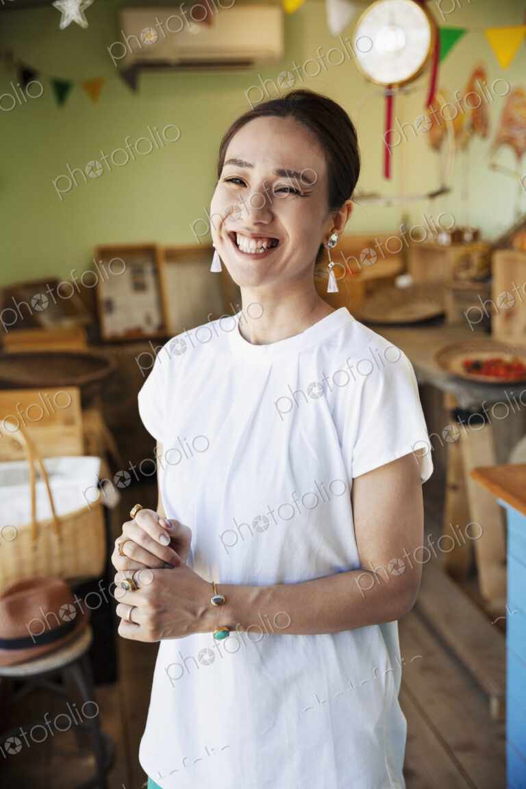 Smiling Japanese woman standing in a farm shop, looking at camera.