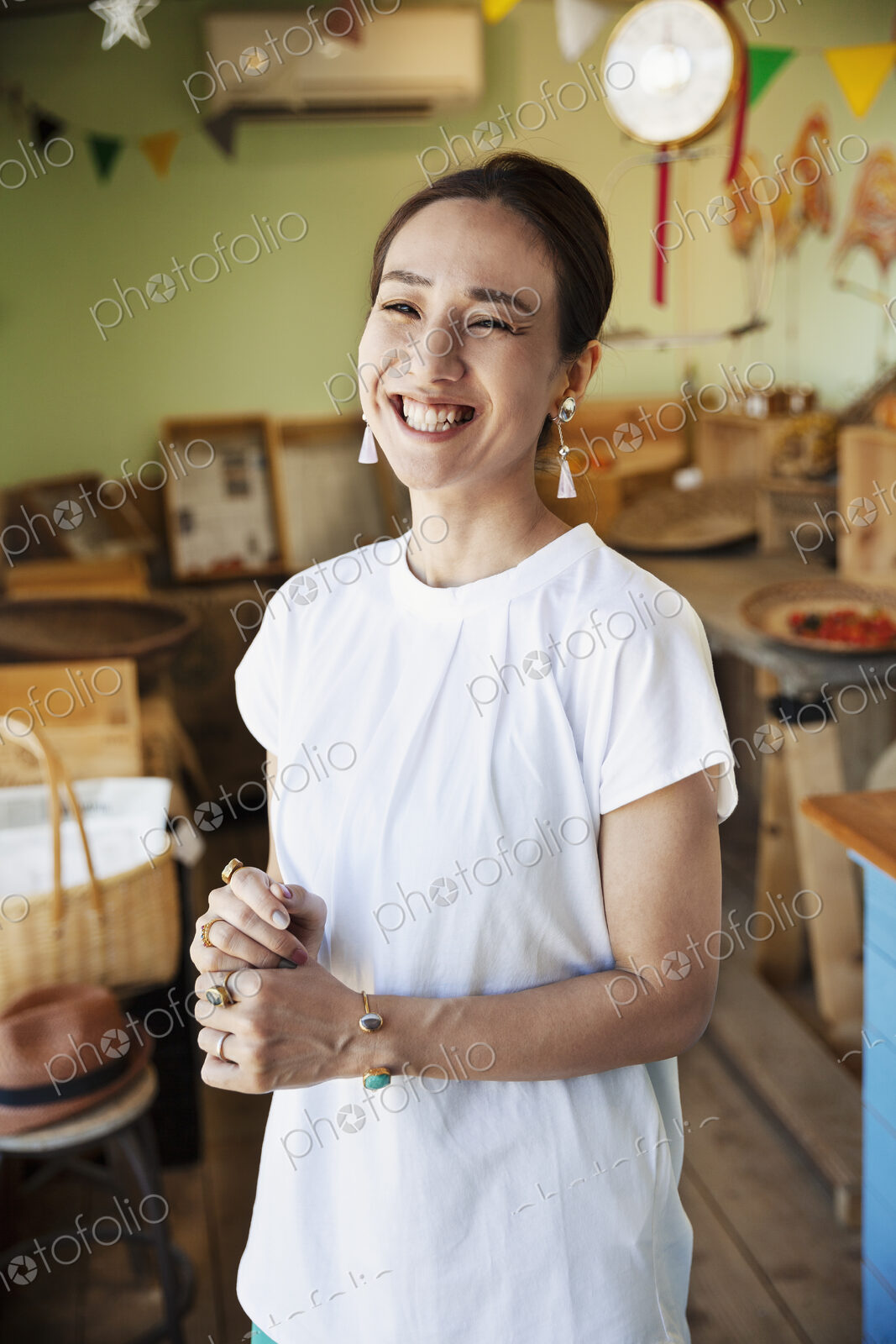 Smiling Japanese woman standing in a farm shop, looking at camera.