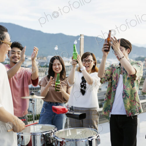 Smiling group of young Japanese men and women standing on a rooftop in an urban… Smiling group of young Japanese men and women standing on a rooftop in an urban…