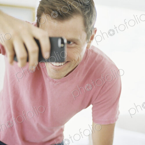 Smiling man taking a picture with a smart phone. Smiling man taking a picture with a smart phone.