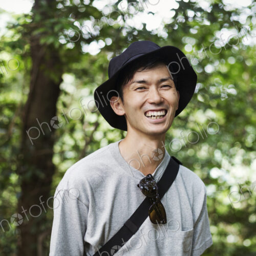 Smiling man wearing a hat standing in a forest. Smiling man wearing a hat standing in a forest.