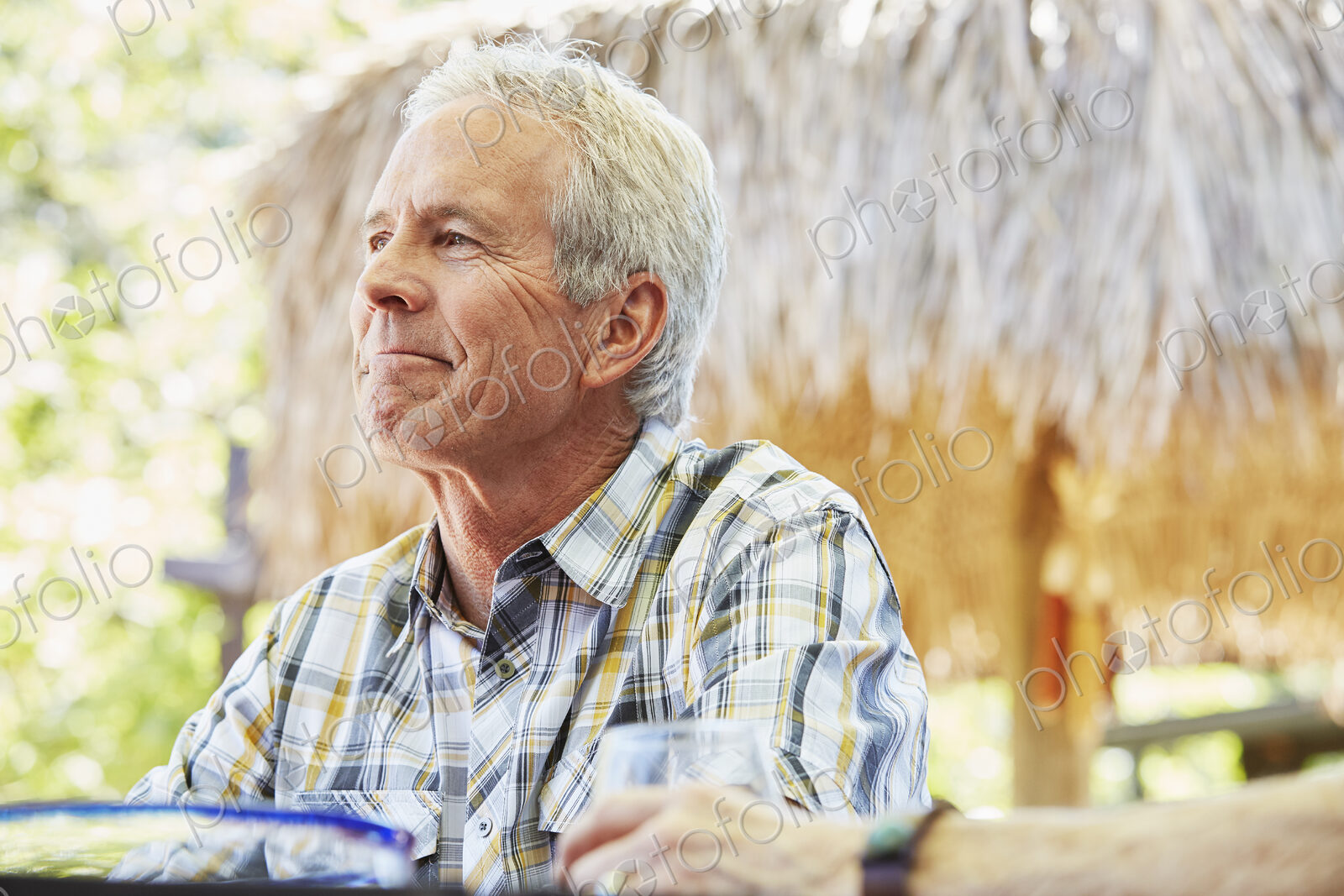 Smiling senior man with grey hair sitting outdoors.