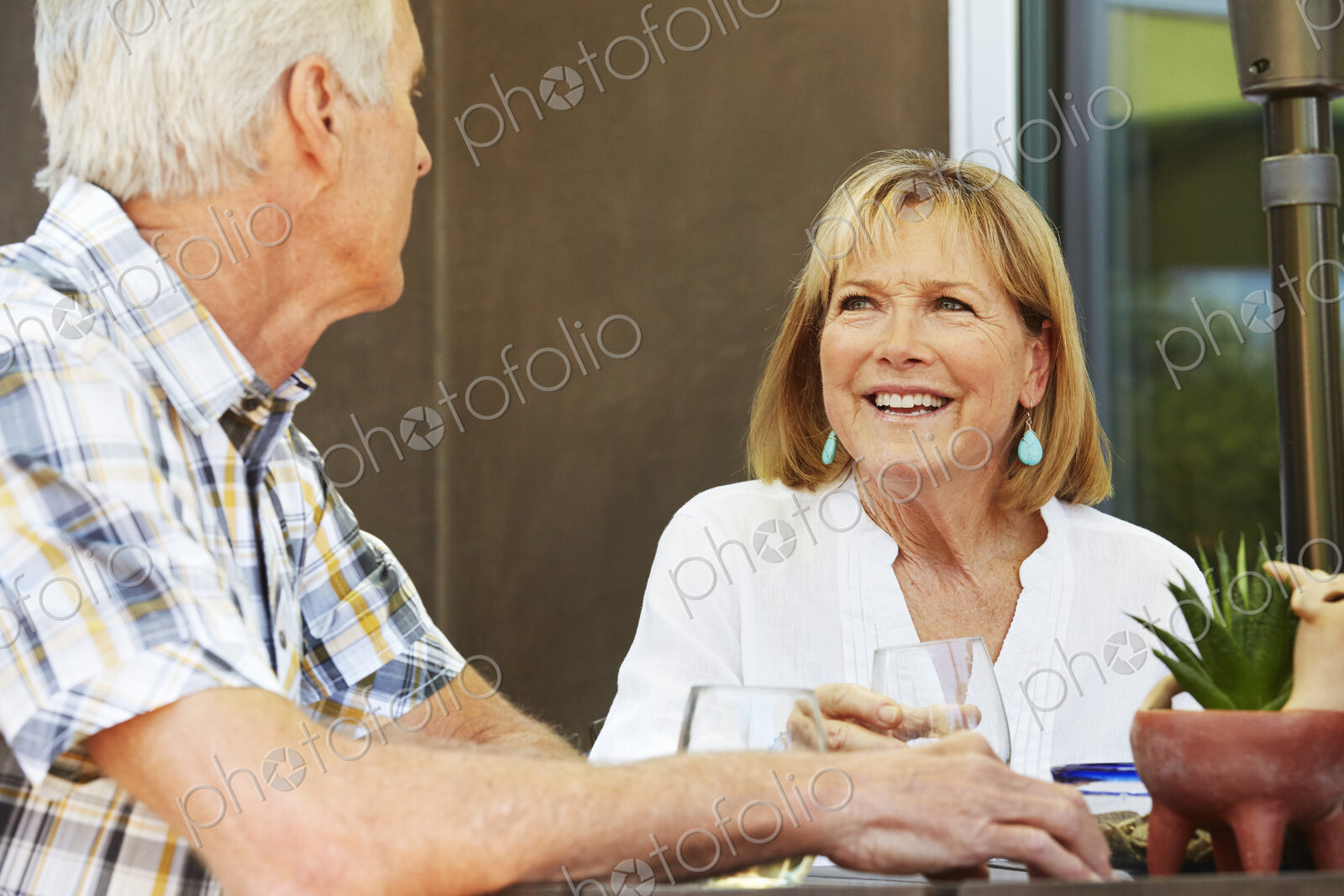 Smiling senior woman and man sitting outdoors.