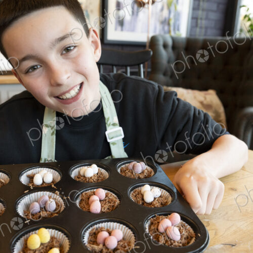 Smiling teenage boy in kitchen presenting freshly made tray of cup cakes to camera. Smiling teenage boy in kitchen presenting freshly made tray of cup cakes to camera.