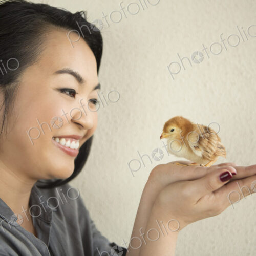 Smiling woman holding a tiny chick in her hands. Smiling woman holding a tiny chick in her hands.