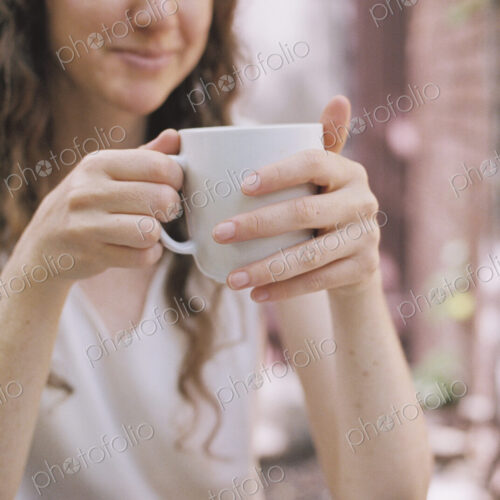 Smiling woman holding a white china teacup.