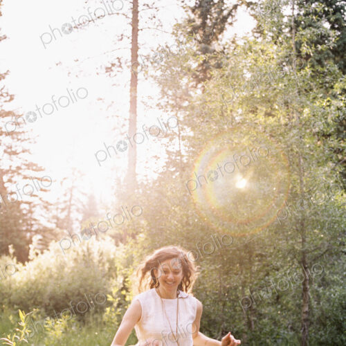 Smiling woman running through a sunlit forest. Smiling woman running through a sunlit forest.