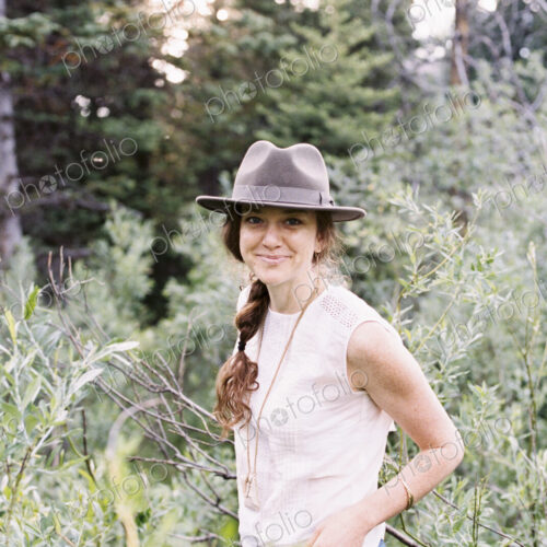 Smiling woman wearing a hat standing in a forest. Smiling woman wearing a hat standing in a forest.