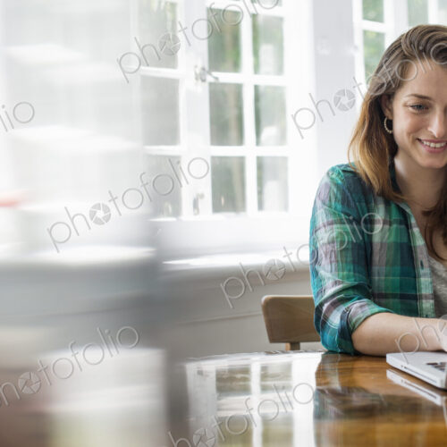Smiling woman with laptop in home office. Smiling woman with laptop in home office.