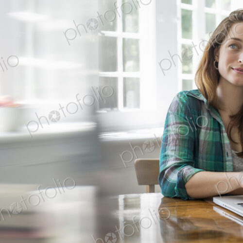Smiling woman with laptop in home office. Smiling woman with laptop in home office.