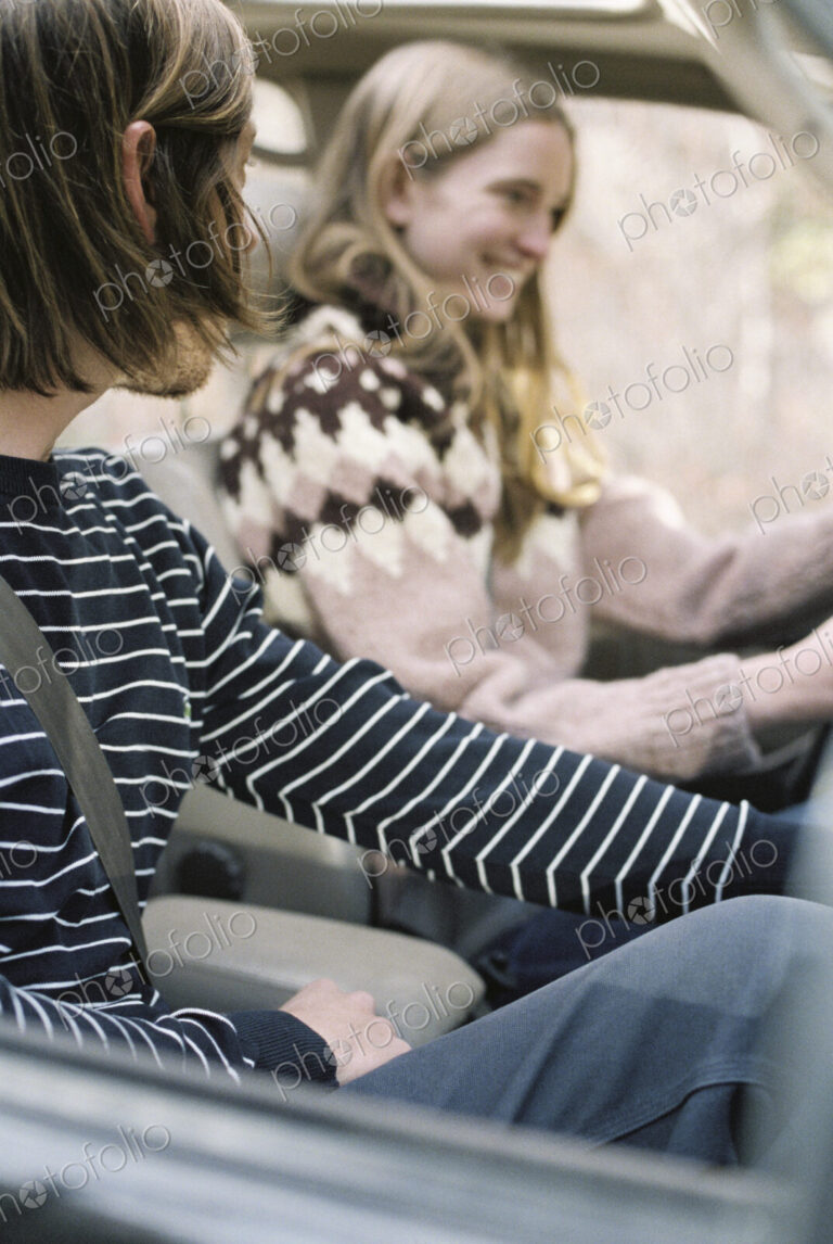 Smiling young couple driving in their car.