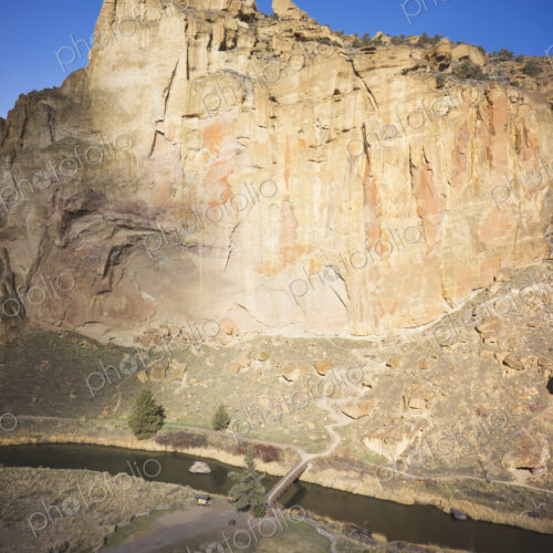 Smith Rocks cliff face in pale sandstone above the water of the Crooked River in Oregon.