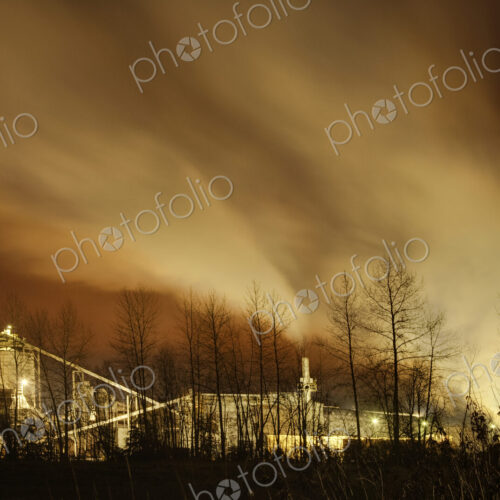 Smoke stacks of a factory at sunset, smoke billowing out at sunset. Smoke stacks of a factory at sunset, smoke billowing out at sunset.