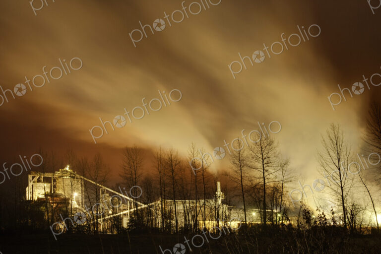 Smoke stacks of a factory at sunset, smoke billowing out at sunset.
