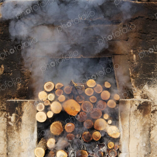 Smoking pile of logs in open fireplace. Smoking pile of logs in open fireplace.