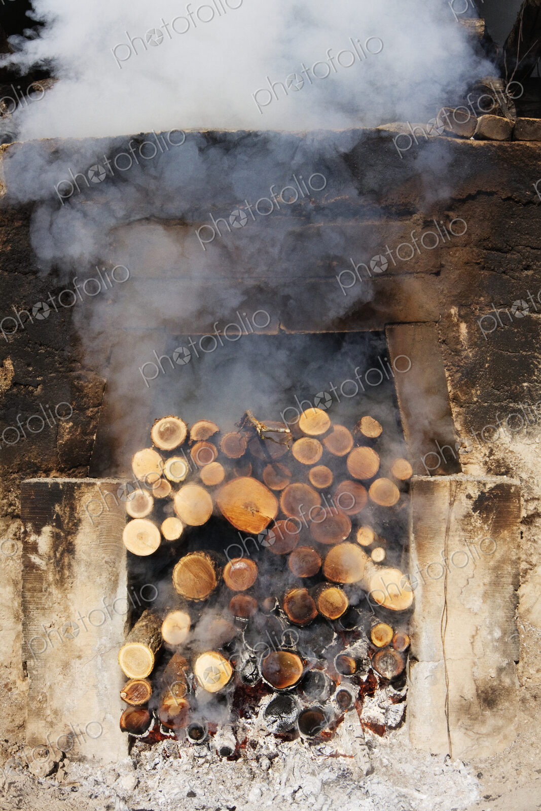 Smoking pile of logs in open fireplace.