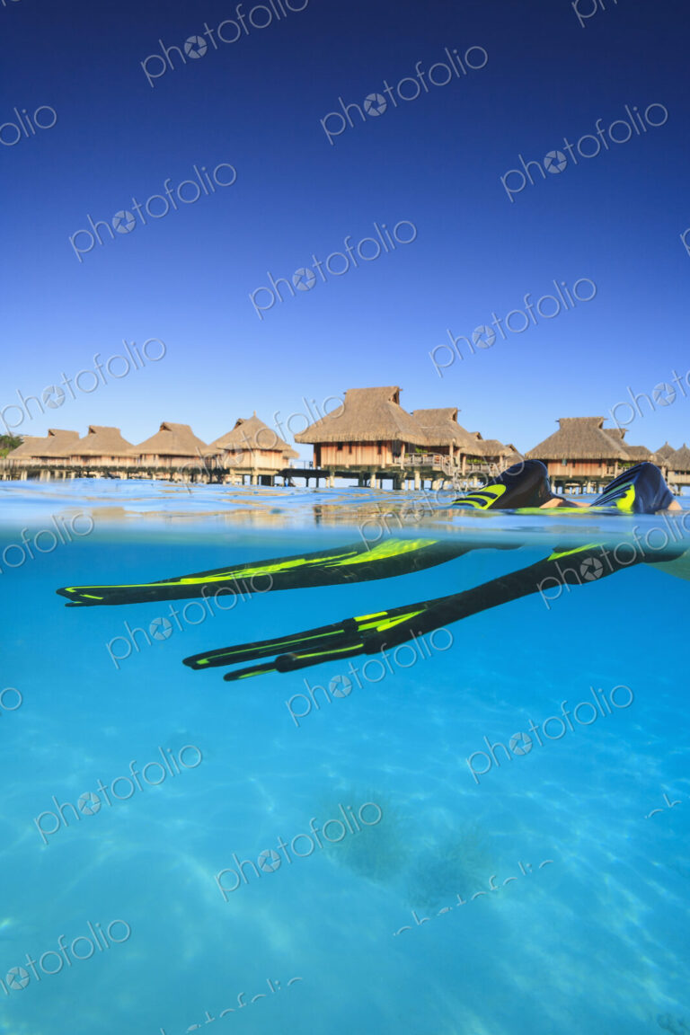 Snorkeler's flippers in tropical water, Bora Bora, French Polynesia