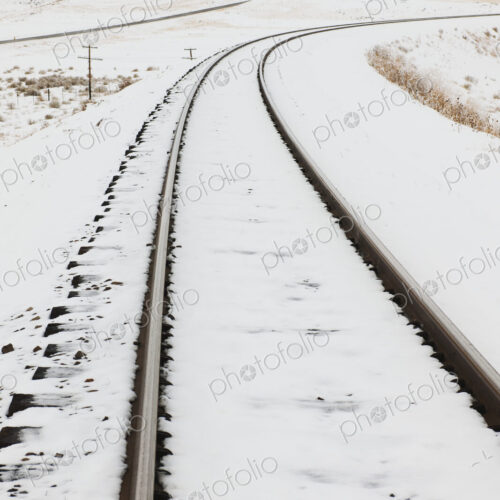 Snow-Covered Railroad Tracks in Rural Landscape Snow-Covered Railroad Tracks in Rural Landscape