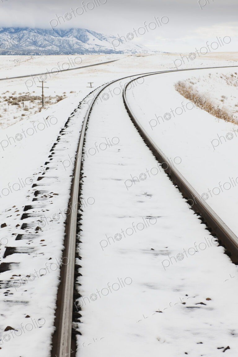 Snow-Covered Railroad Tracks in Rural Landscape