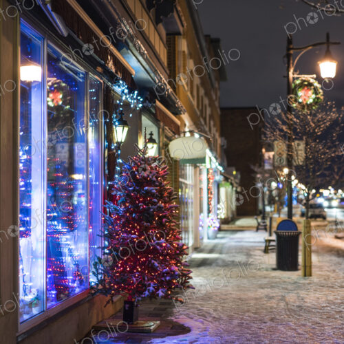 Snow and Christmas tree on city sidewalk at night Snow and Christmas tree on city sidewalk at night