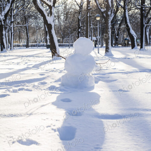 Snowman and footprints in snowy park Snowman and footprints in snowy park