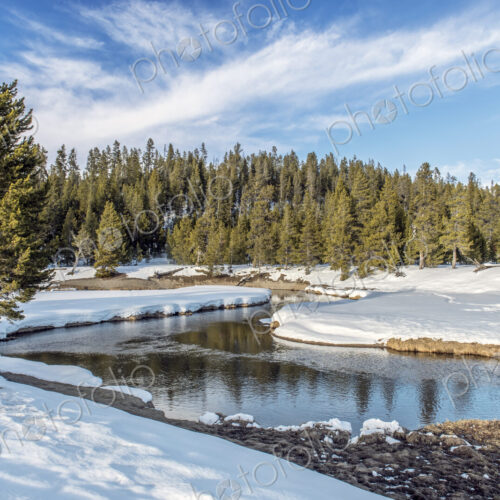 Snowy fields and hills near remote stream