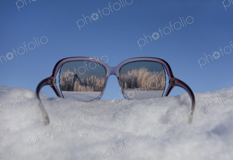Snowy winter landscape view through sunglasses. Reflection.
