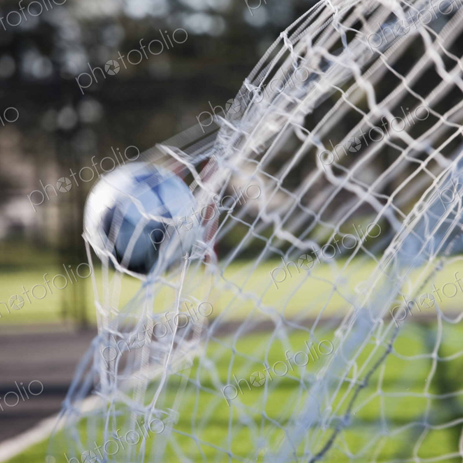 Soccer ball hitting the back of a football net.