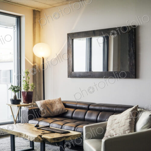 Sofa and armchair near a city living room window Sofa and armchair near a city living room window