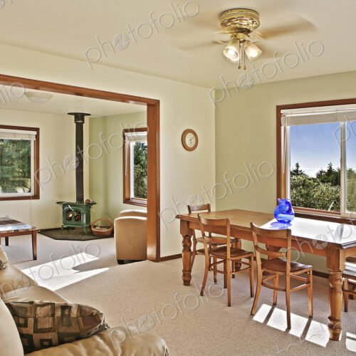 Sofa, dining table and wood stove in rustic open living space Sofa, dining table and wood stove in rustic open living space