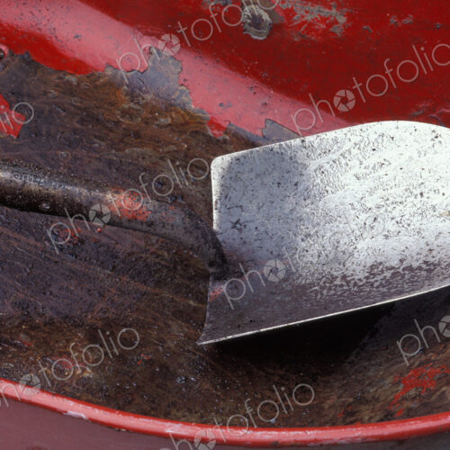 Spade in an empty red wheelbarrow. Spade in an empty red wheelbarrow.