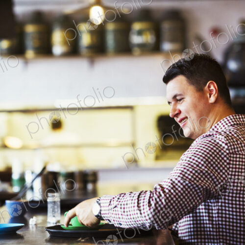 Specialist coffee shop. A man seated at a counter with a cup of coffee. Specialist coffee shop. A man seated at a counter with a cup of coffee.