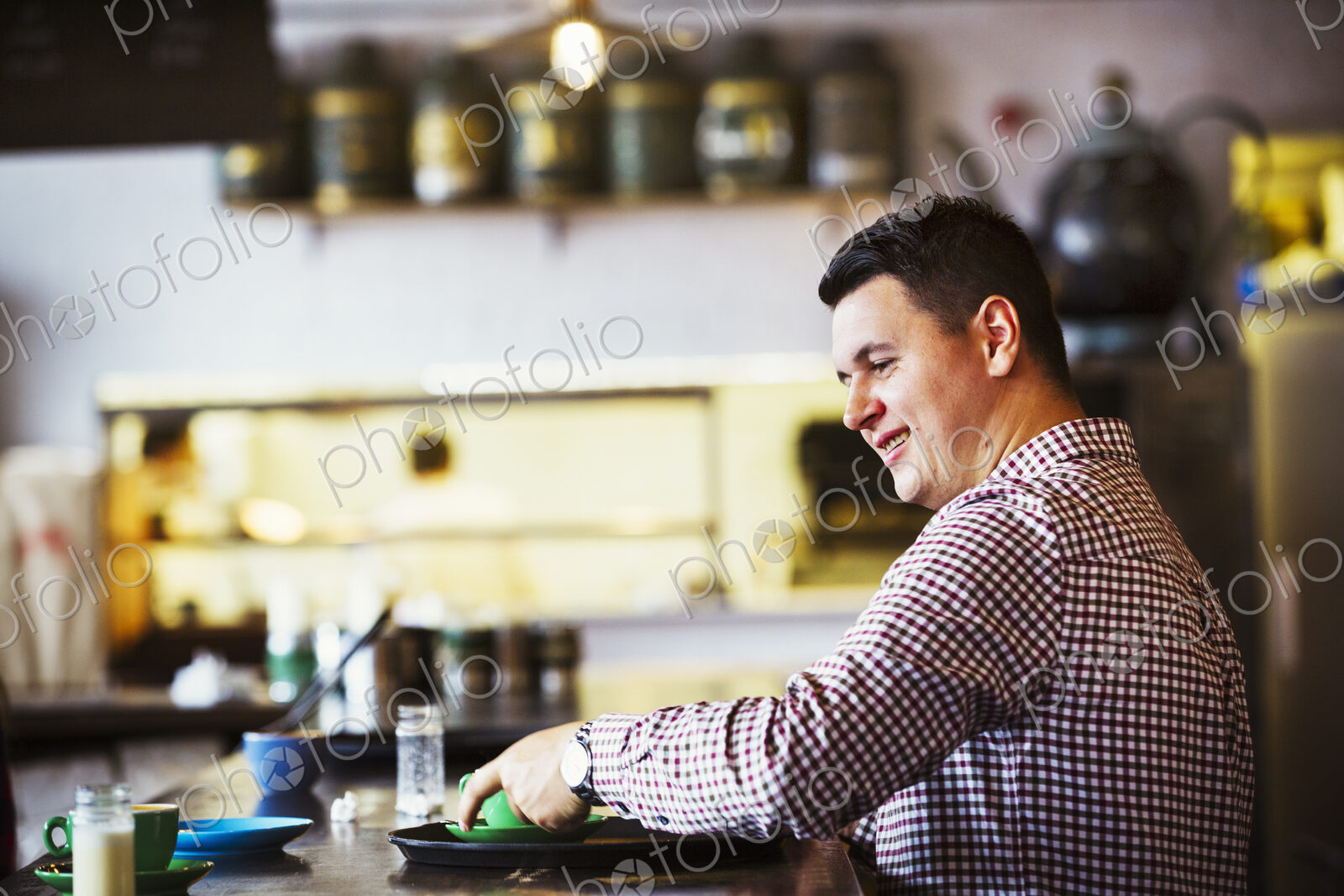 Specialist coffee shop. A man seated at a counter with a cup of coffee.