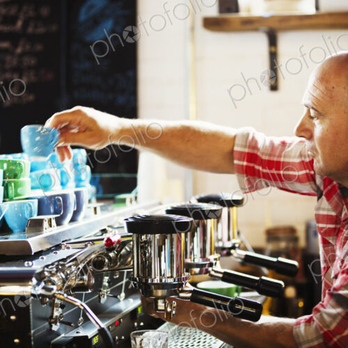 Specialist coffee shop. A man working a coffee machine making coffee. Specialist coffee shop. A man working a coffee machine making coffee.