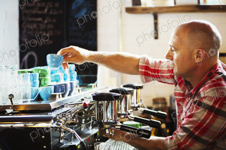 Specialist coffee shop. A man working a coffee machine making coffee.