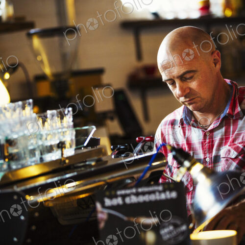 Specialist coffee shop. A man working behind the counter at a coffee shop. Specialist coffee shop. A man working behind the counter at a coffee shop.