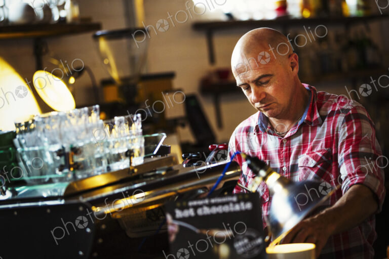 Specialist coffee shop. A man working behind the counter at a coffee shop.