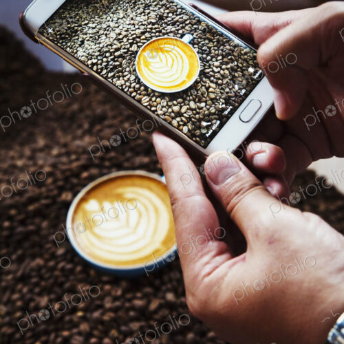 Specialist coffee shop. A person taking a picture with a smart phone of a cup of… Specialist coffee shop. A person taking a picture with a smart phone of a cup of…