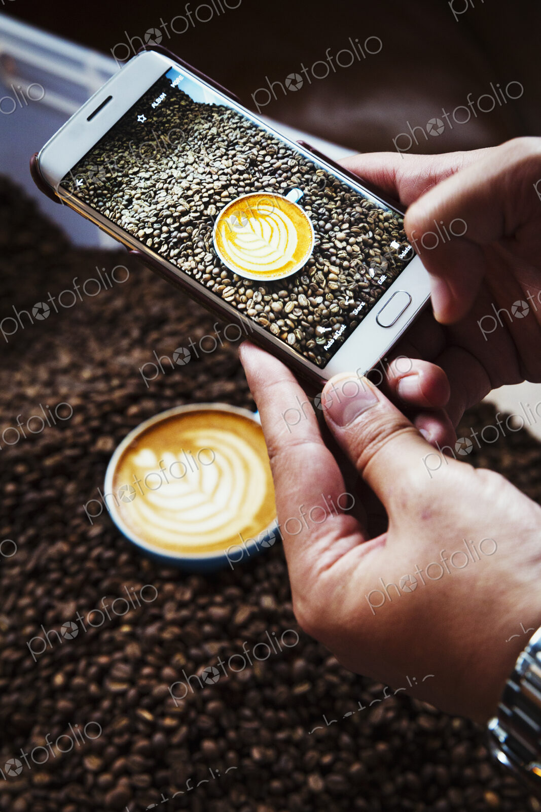 Specialist coffee shop. A person taking a picture with a smart phone of a cup of…