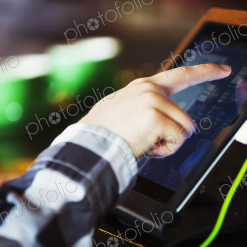 Specialist coffee shop. A person using a touch screen at a till. Specialist coffee shop. A person using a touch screen at a till.