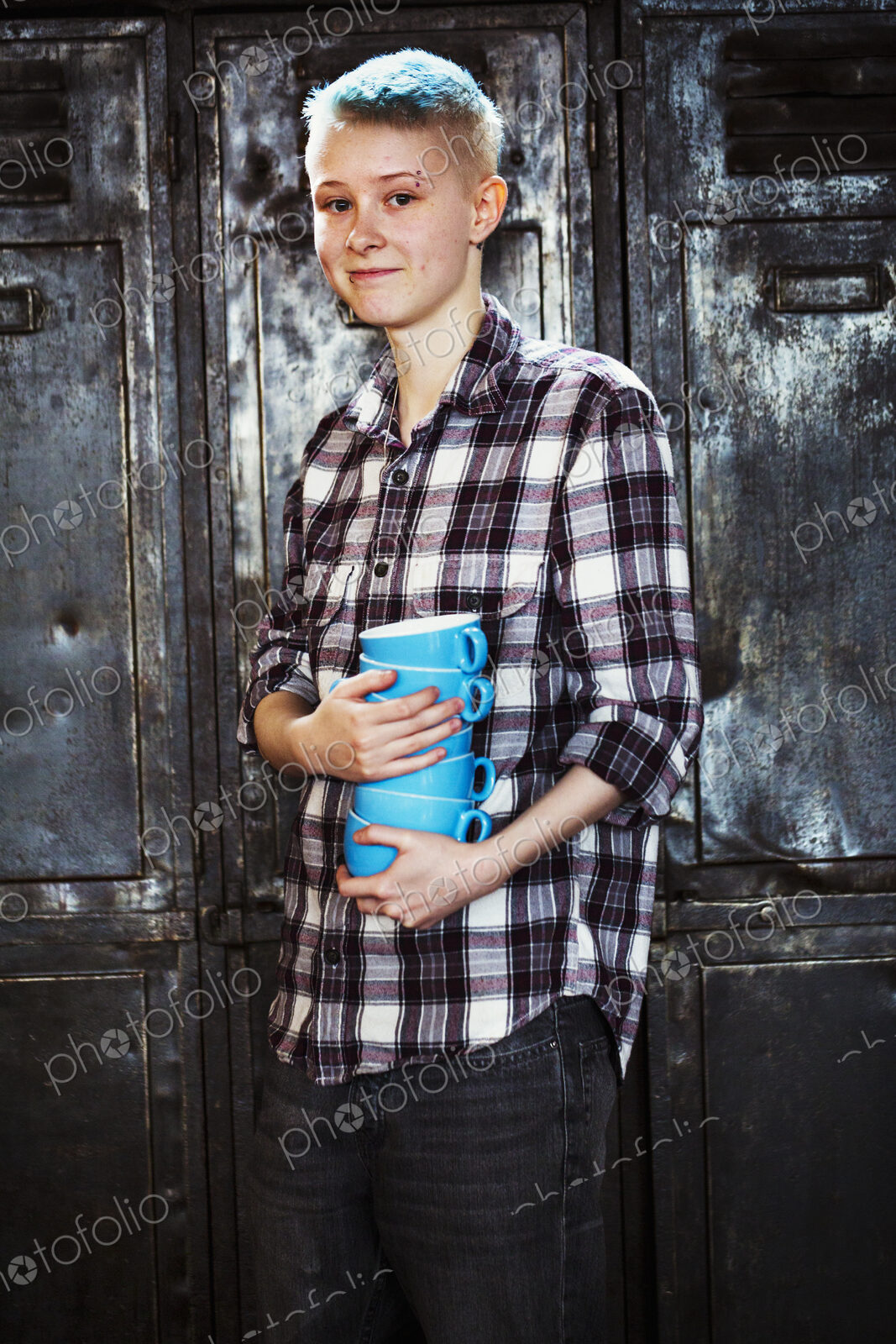 Specialist coffee shop. A young girl carrying a stack of blue coffee cups.