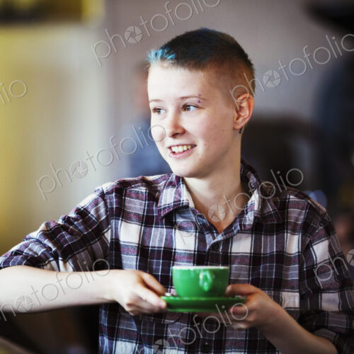 Specialist coffee shop. A young persion carrying a cup of coffee. Specialist coffee shop. A young persion carrying a cup of coffee.