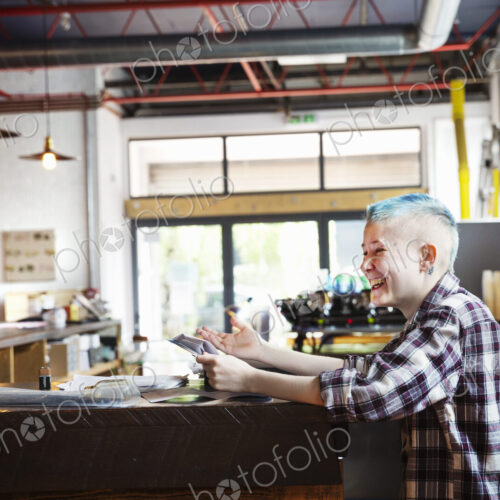 Specialist coffee shop. A young person seated at a counter laughing. Specialist coffee shop. A young person seated at a counter laughing.