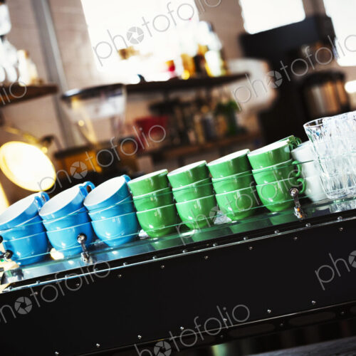 Specialist coffee shop. Blue and green coffee cups stacked up on the counter. Specialist coffee shop. Blue and green coffee cups stacked up on the counter.