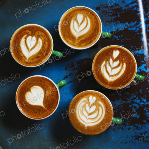 Specialist coffee shop. Cups of coffee with patterns in the froth on the top. Specialist coffee shop. Cups of coffee with patterns in the froth on the top.