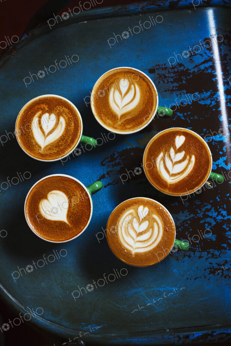 Specialist coffee shop. Cups of coffee with patterns in the froth on the top.