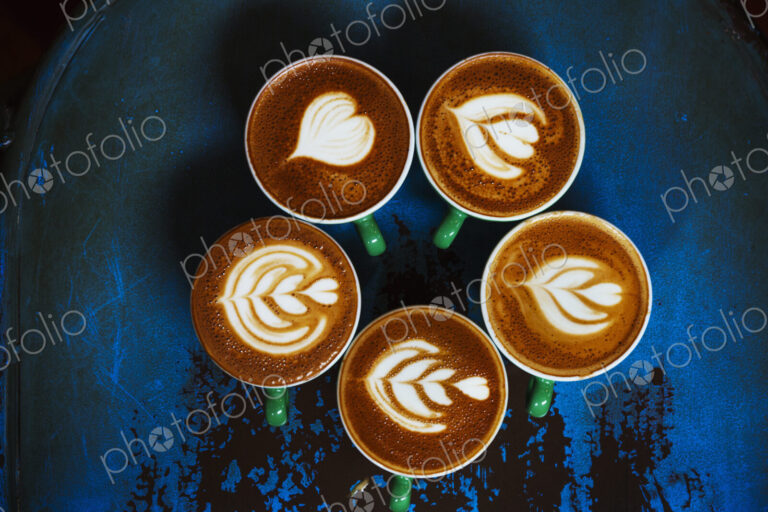 Specialist coffee shop. Cups of coffee with patterns in the froth on the top.