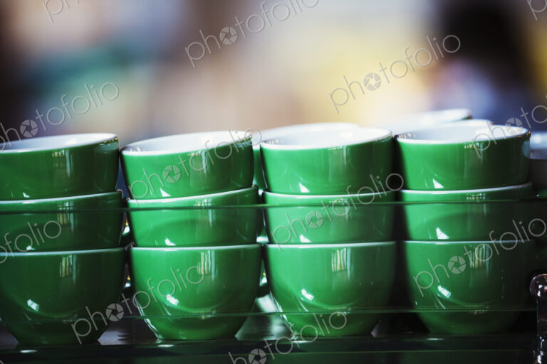 Specialist coffee shop. Green coffee cups stacked up.